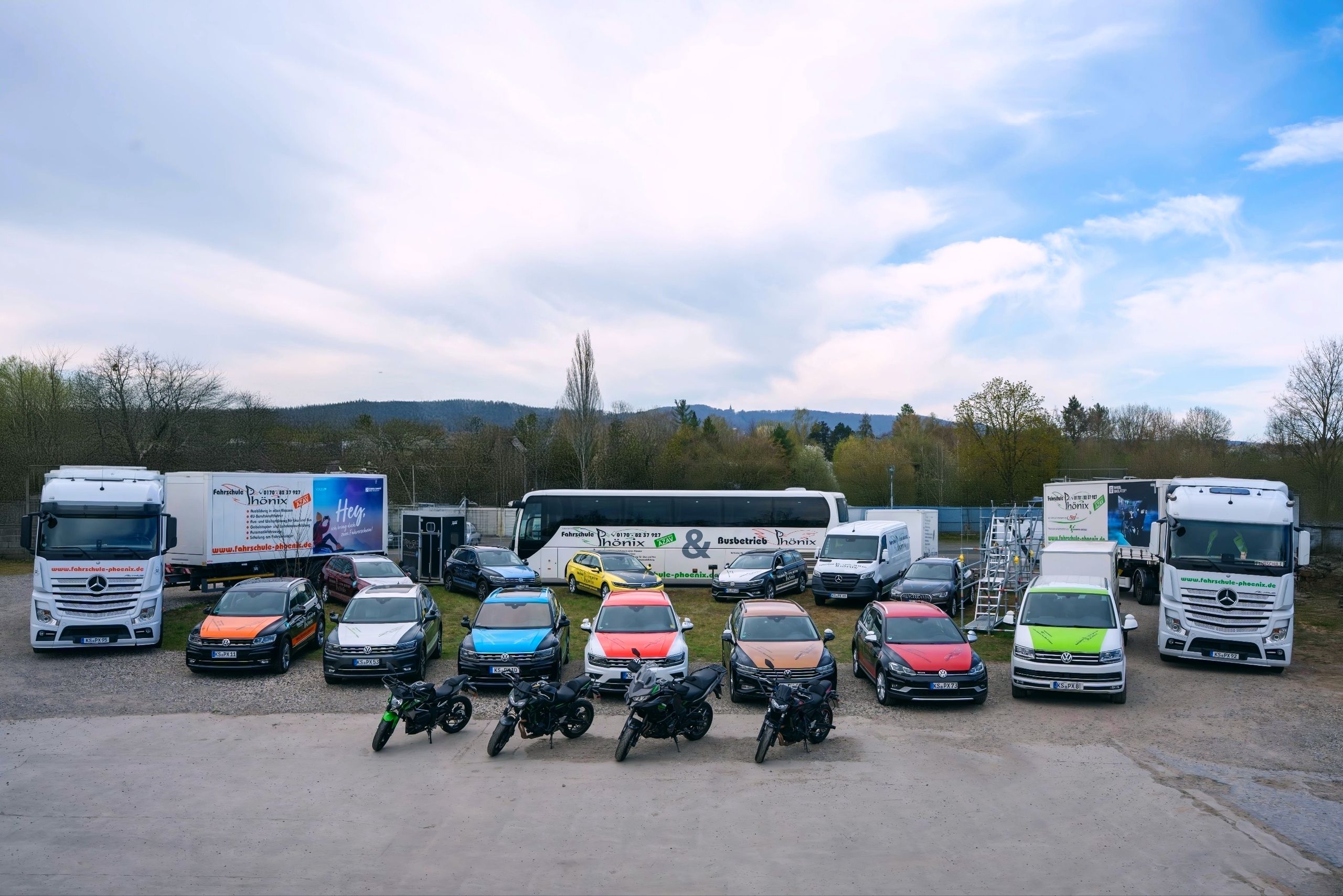 Fuhrpark der Fahrschule Phönix mit Pkw, Lkw, Motorrädern und Bussen auf einem Gelände